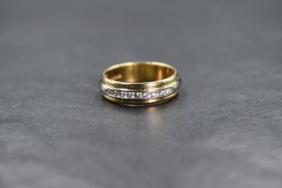 An 18ct gold two tone diamond set band, the central raised band set with nine round brilliant cut