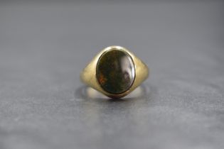A 9ct gold bloodstone set signet ring, the central oval bloodstone in a bezel setting, marked 375,