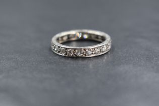 A white metal diamond set full eternity ring having twenty one pave set diamonds total approx 1ct,