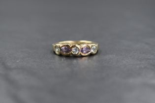 A 9ct gold amethyst and topaz set band, the three round cut pale blue topaz alternating with two
