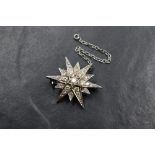 An 18ct white gold diamond set star brooch, having twenty-five round brilliant cut diamonds,