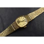 A ladies vintage 9ct gold wrist watch by Tissot having a baton numeral dial to gold coloured face in