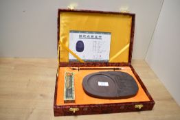 A 21st century Chinese Duan inkstone, of shaped oval form, decorated with Huaiji Hydropower Station,