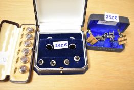 A cased set of six gold tone mother-of-pearl set button studs, along with a set of silver and onyx