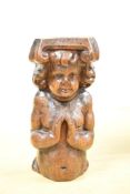 A 17th-century English Carved Oak Cherub, featuring tender features, gracefully clasped hands in