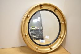 A mid 20th-century gilt framed Regency portholeof convex circular form mirror, featuring a series of