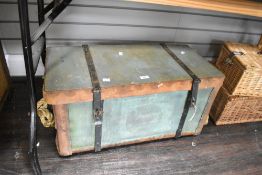 A large late 19th to early 20th-century wicker travel trunk, having a green canvas exterior