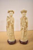 A pair of 20th-century Chinese carved resin imperial figures depicting an emperor and empress,