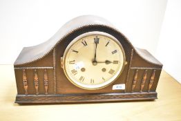 A 1940's oak arched mantel clock, with bead and spindled moulding and Roman hours, the striking