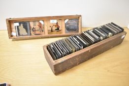 A quantity of Victorian Magic Lantern glass image slides in a wooden case, typically made of two