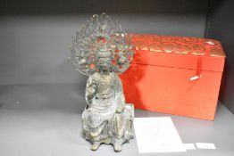 A reproduction Chinese cast and patinated metal figure of seated Buddha, cast in three pieces with