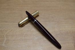 A Parker 51 aerometric fill fountain pen in Dark Burgundy with Rolled Gold converging lines cap.