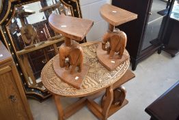 A tribal art style occasional table having regal style carved illustration , with three (one