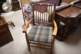 A traditional period style spindle back armchair having tweed upholstery to seat