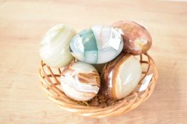 A quantity of 20th-century polished hard stone eggs, of natural onyx variations, displaying a