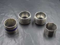 A pair of late Victorian silver napkin rings, having floral scroll decoration with shield cartouches