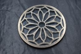 A silver mounted glass coaster, of circular form having a pierced floral motif silver mount, marks