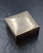 A George V silver cigarette box, of hinged square form, having a personalised inscription to the lid