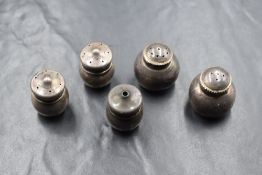 A pair of Eastern white metal salt and peppers, of small bulbous form having landscape scenes to the