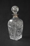 An Elizabeth II silver mounted glass decanter, the decanter of square form having floral moulding