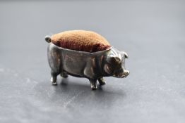 A white metal novelty pin cushion, in the form of a pig, having velvet to the back, indistinct