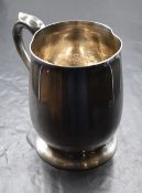 An Elizabeth II silver tankard, of traditional form having a scroll handle, raised on a circular