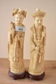 A pair of 20th-century Chinese carved resin imperial figures depicting an emperor and empress,