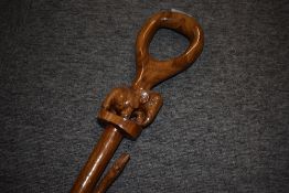 An oriental style wooden carved walking stick with a carved Elephant just below the handle and a