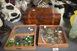 A wooden chest having a central oval plaque and inlay decoration, containing an assortment of