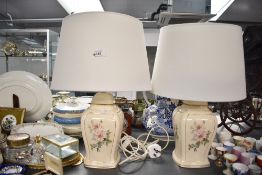 Two 20th-century ceramic table lamps, having delicate pink floral decoration with gilded detailing