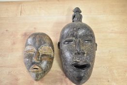 Two African hand-carved wooden tribal masks, presumed Ivory Coast examples, featuring expressive