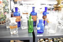 A selection of 19th- to early 20th-century apothecary glass bottles, to feature three cobalt blue