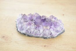 A small 20th-century Amethyst geode, featuring a deep purple quartz, 13cm in length and 4cm in