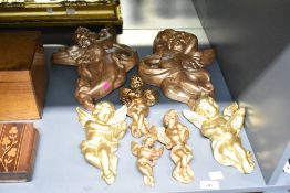 A selection of vintage gilt resin cherub wall hangings of varying sizes, to include two sets of