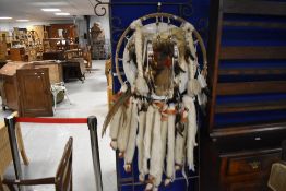 A large Native American inspired dream catcher wall decoration, constructed from animal skin, wool