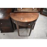 A George III mahogany demi-lune tea table, the hinged top with hinged supports to the rear, all on