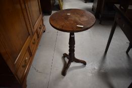 A 19th century yew wood stem table, the circular top above the turned baluster column and three down