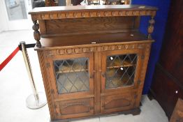 A Stanley Wood of Olney reproduction oak court cupboard style bookcase/display cabinet, having two