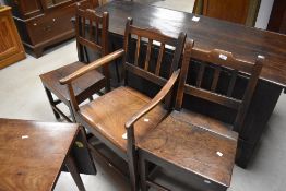 A group of three 18th century oak chairs, two single and one carver, each with shaped top rail and