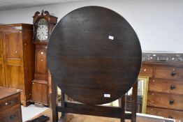An early/mid 20th century oak folding occasional table, with circular top and square section