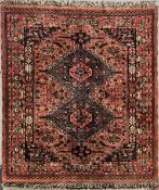 An antique Afghan Khan rug in rich red, forest green, deep purple, black and beige wool, having a