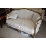 A vintage settee in the French style having limed effect frame and neutral upholstery, width approx.