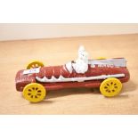 A painted cast model of Michelin Man in vintage racing car