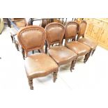 A set of twelve (ten plus two) Victorian oak dining chairs having spoon backs and overstuffed seats,