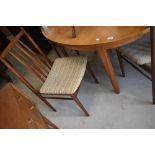 A vintage teak dining table and set of four rail back dining chairs, possibly McIntosh snd /or G