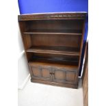 A dark stained Ercol or similar bookshelf with double cupboard under, dimensions approx. height