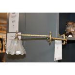 A early 20th-century brass articulated library wall light, featuring an decorative Art Deco-style