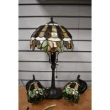 A 20th-century Tiffany-style table and two wall lights featuring green, cream and amber panelled