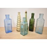 A selection of late 19th to early 20th-century coloured glass bottles, to feature blue, amber, green