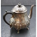 A Victorian silver teapot, of bulbous form having embossed foliate decoration, raised on four hoof